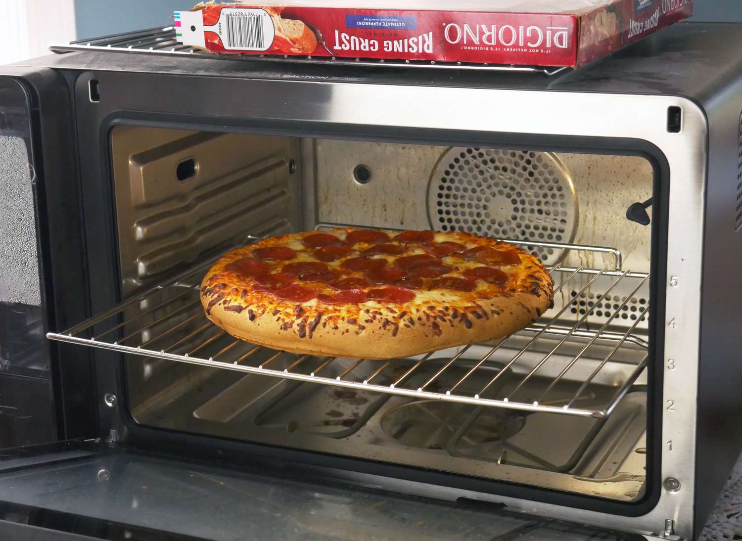 a pizza baking in a countertop oven