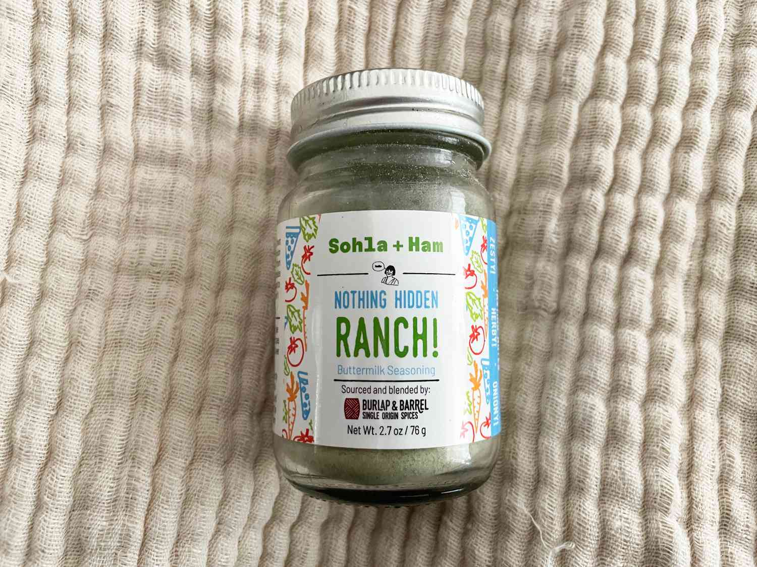 A bottle of ranch seasoning on a cream surface.