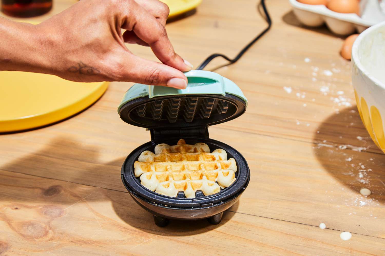 Person opening Dash Mini Waffle Maker