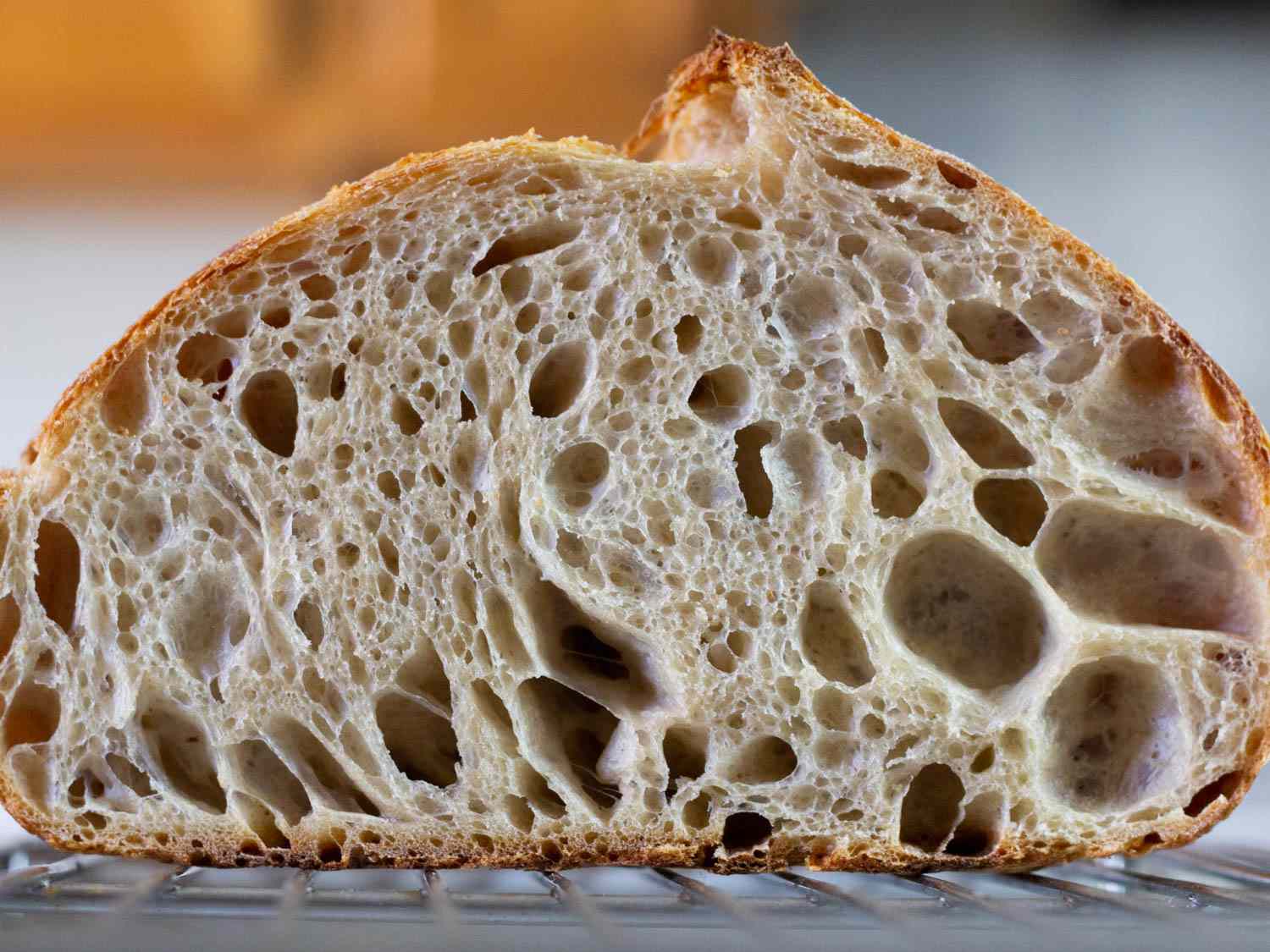 The airy interior of a sourdough loaf, cut in half and showing the large air pockets in the crumb
