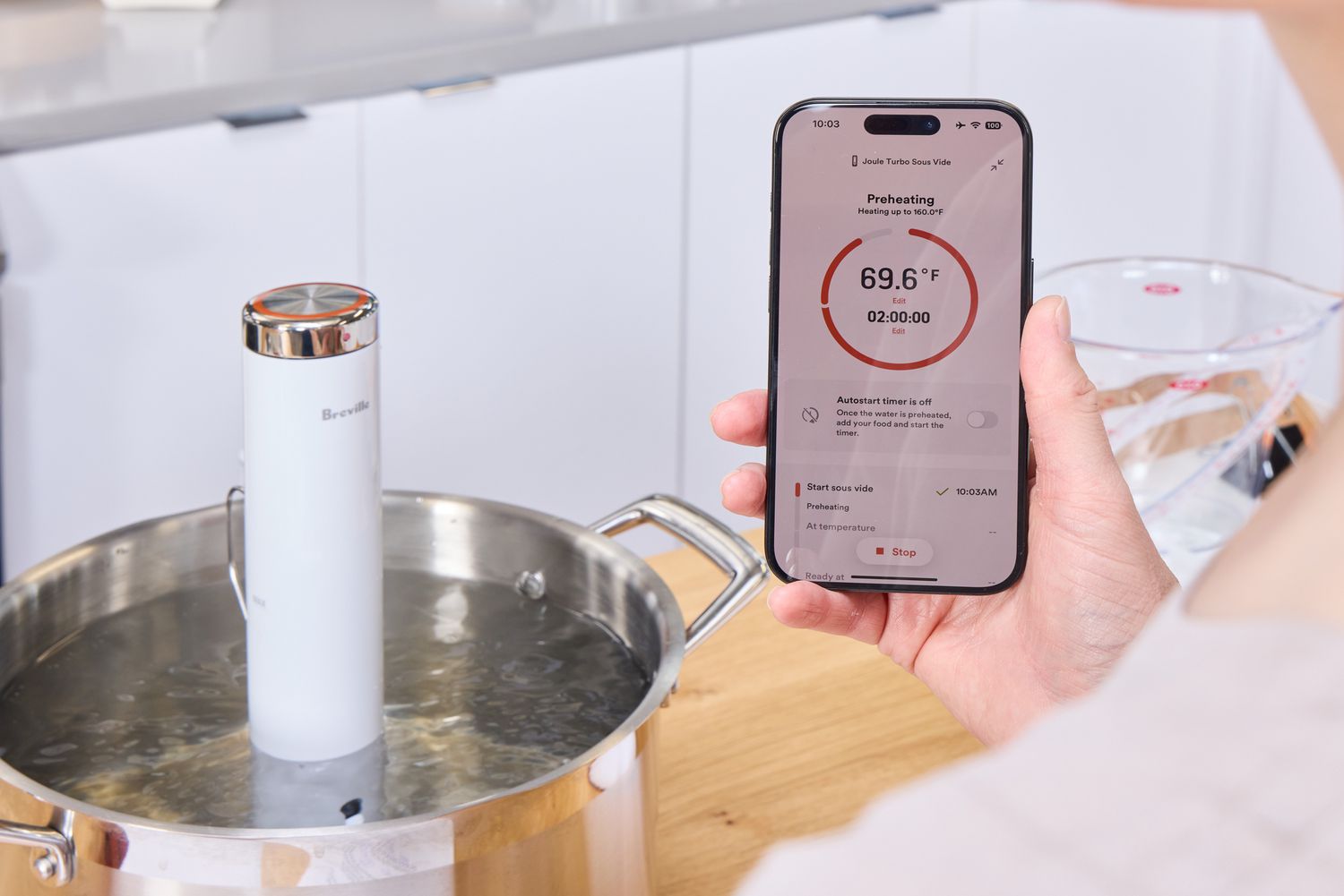 A person checks the temperature of the Breville Joule Turbo Sous Vide on their smartphone