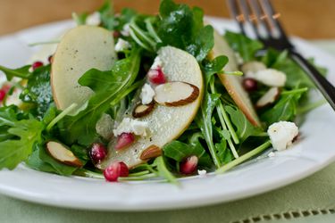 Closeup of Arugula, Apple, and Pomegranate Salad with Cider-Honey Vinaigrette.