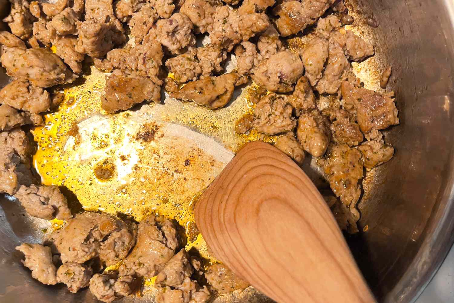 Sausage in a pan being stirred with Jonathan’s Spoons Spootle