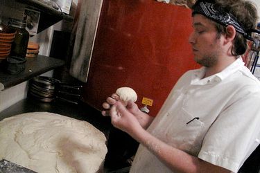 Anthony Falco, also known as Tony Calzone, shaping dough in a professional kitchen. 