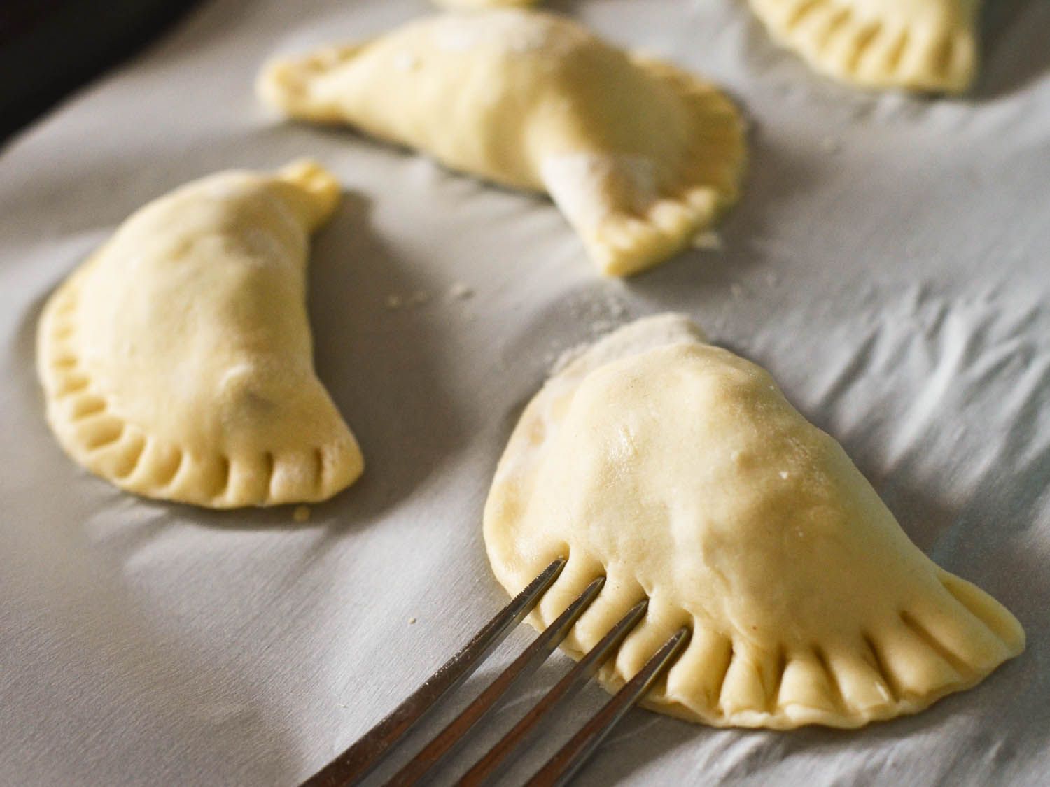 Formed pierogi crimped shut with fork.