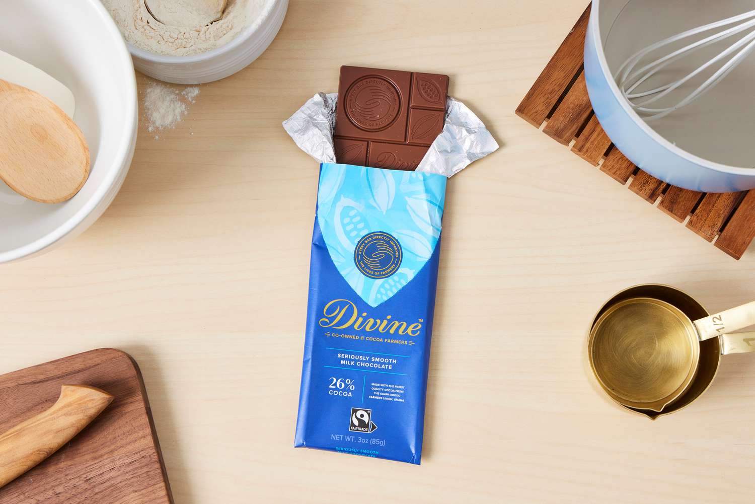 A partially unwrapped Divine milk chocolate bar.