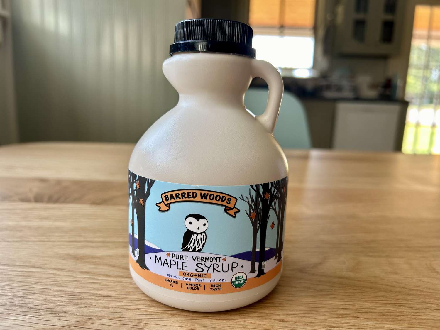 A bottle of Barred Woods maple syrup on a kitchen table