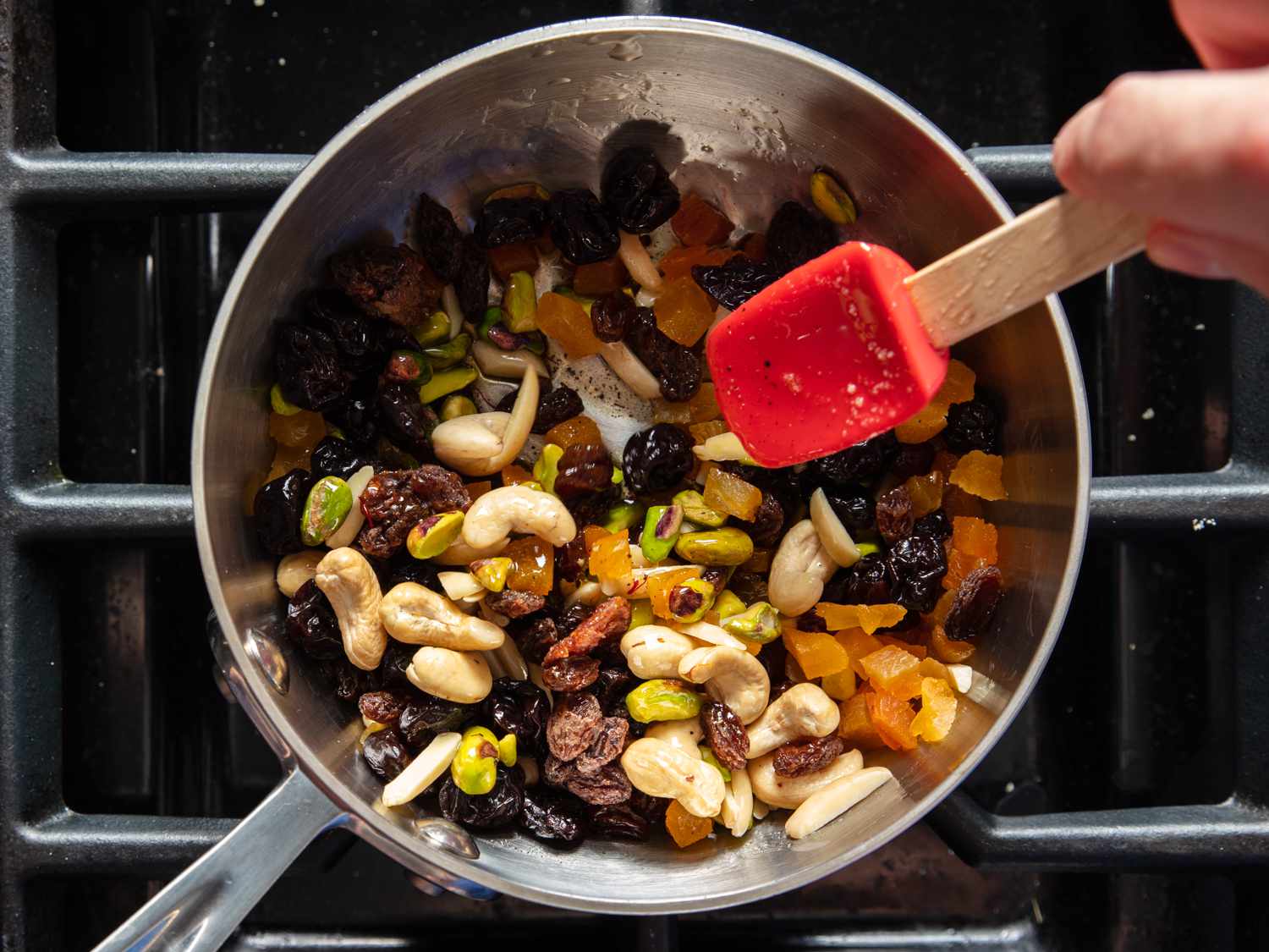 Dried fruit and nut garnish for halva being prepared in a saucepan