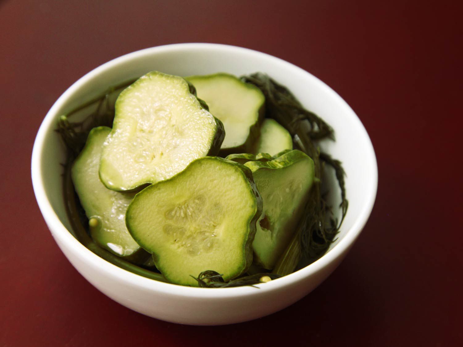 A bowl of dill pickle chips. 