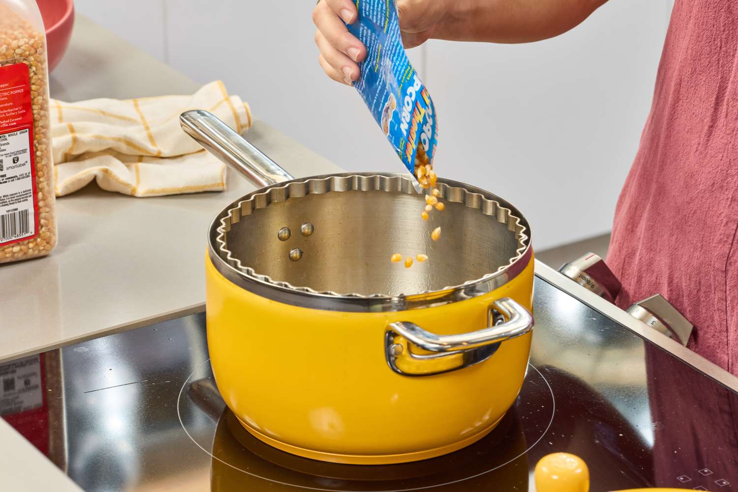 A person pours popcorn kernels into the Popsmith The Popper