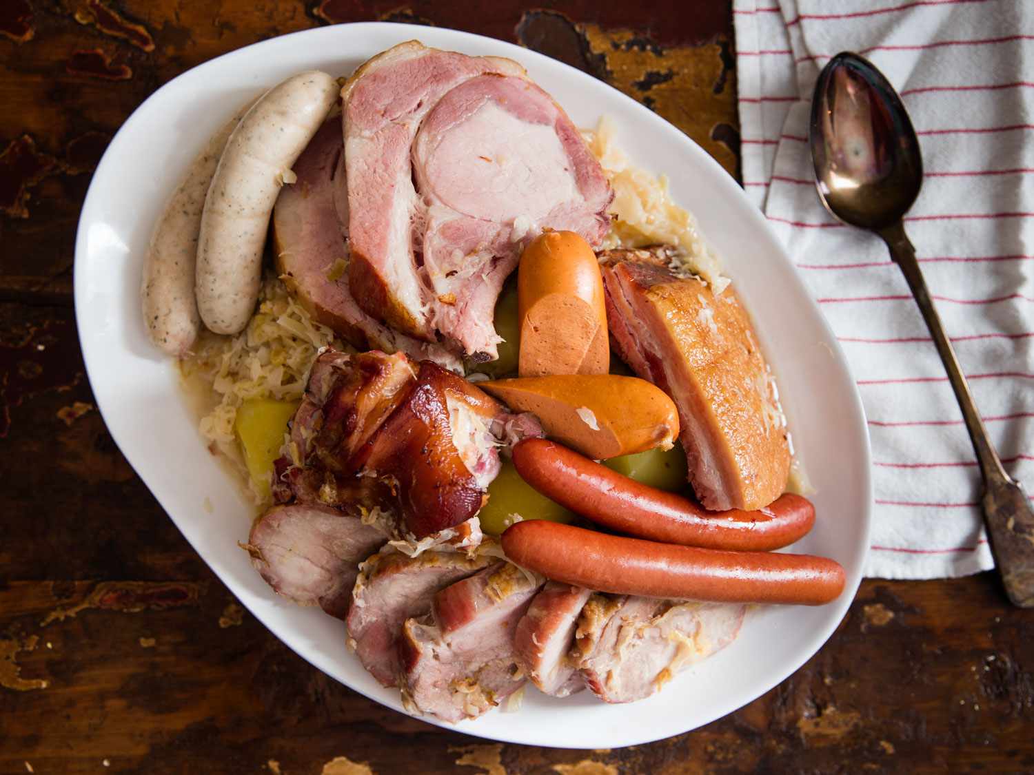 Overhead view of choucroute garnie à l'Alsacienne, served on a large porcelain platter.