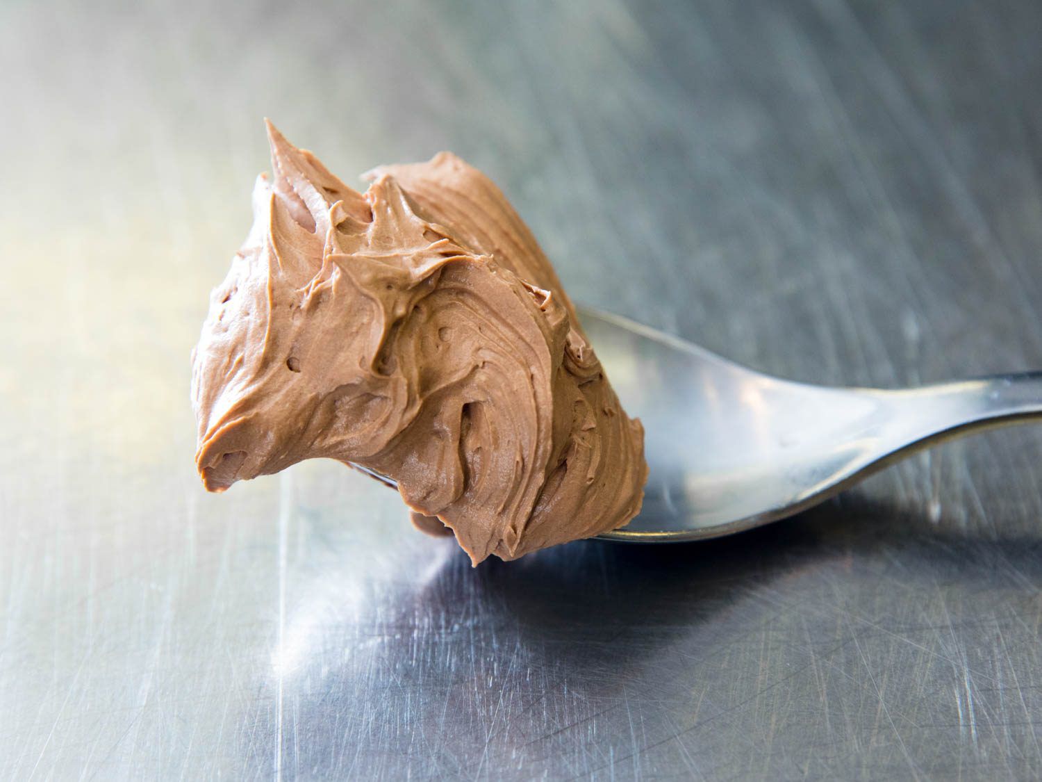 A spoonful of chocolate Swiss buttercream frosting.
