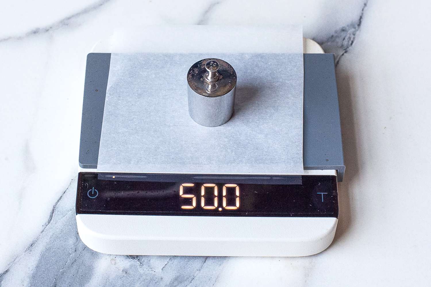 Acaia Lunar Scale displaying 50.0 with a metal weight placed on it