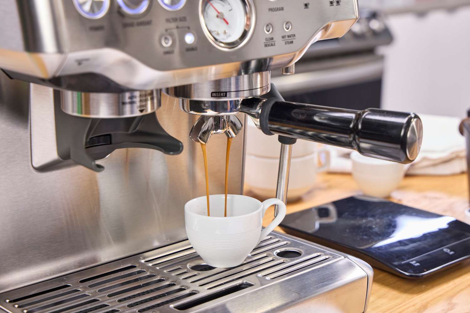 A person brews espresso in the Breville The Barista Express Espresso Machine