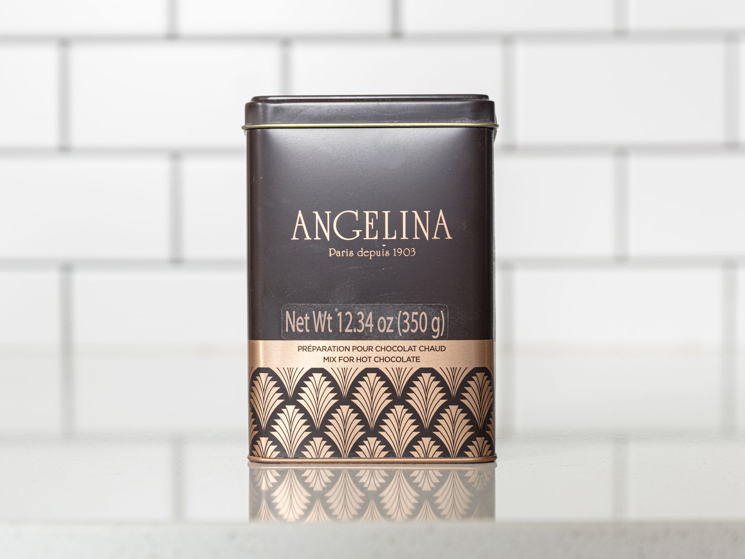 Angelina tin of hot chocolate on white surface with white tile background