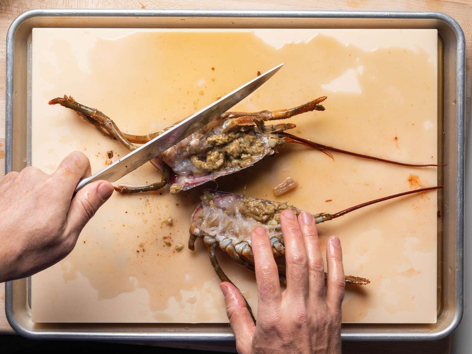 Chopping a lobster body into pieces.