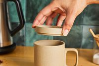 Adding a ceramic lid to a ceramic mug.