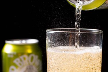 Dr. Brown's Cel-Ray soda being poured from a can into a tall glass.