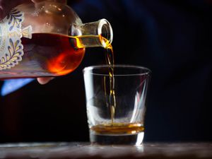 Amaro Nonino is poured from the bottle into a small glass. 