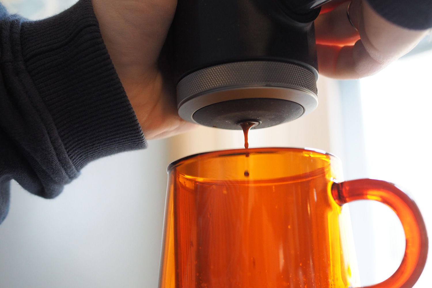 person adding sauce to drink