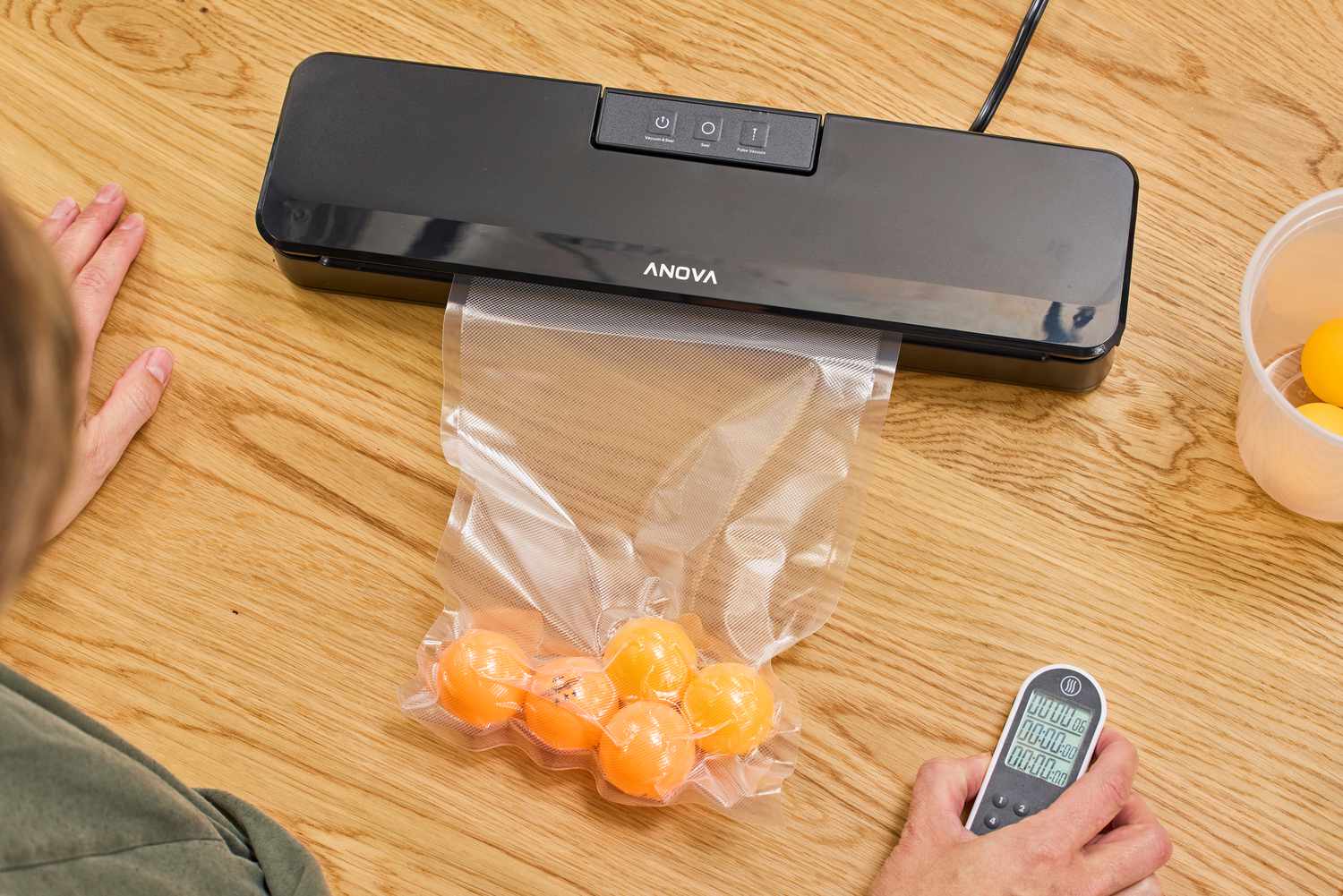 A bag filled with ping pong balls is vacuum sealed using the Anova Precision Sous Vide Vacuum Sealer