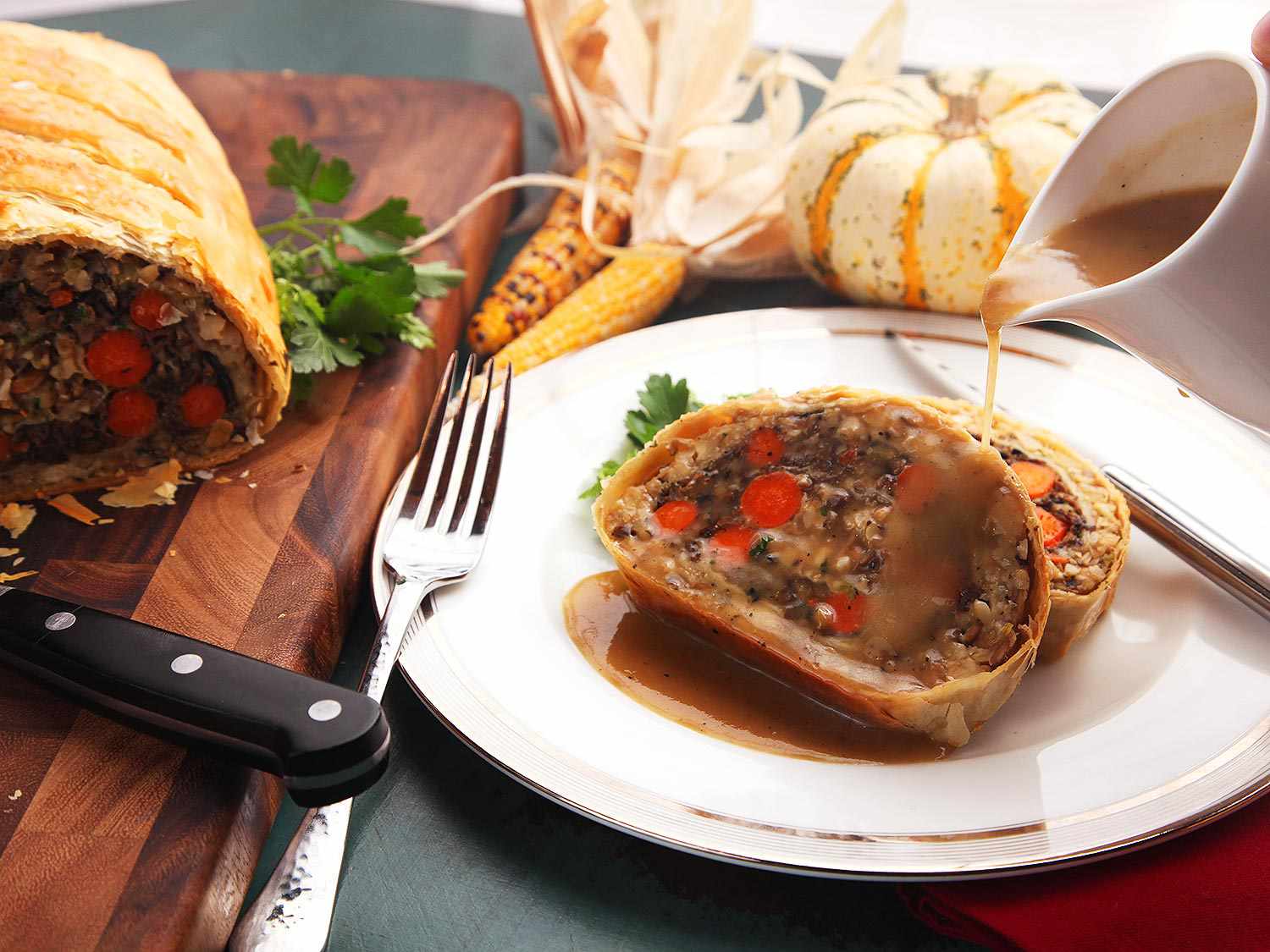 Pouring gravy over vegetables Wellington slices.