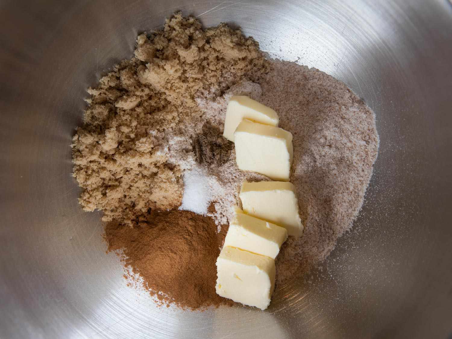 Whole wheat flour, brown sugar, salt, spices, and pieces of butter in a mixer bowl to make streusel topping.