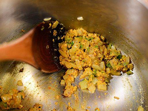 Stirring together onion and spices for banana ketchup.