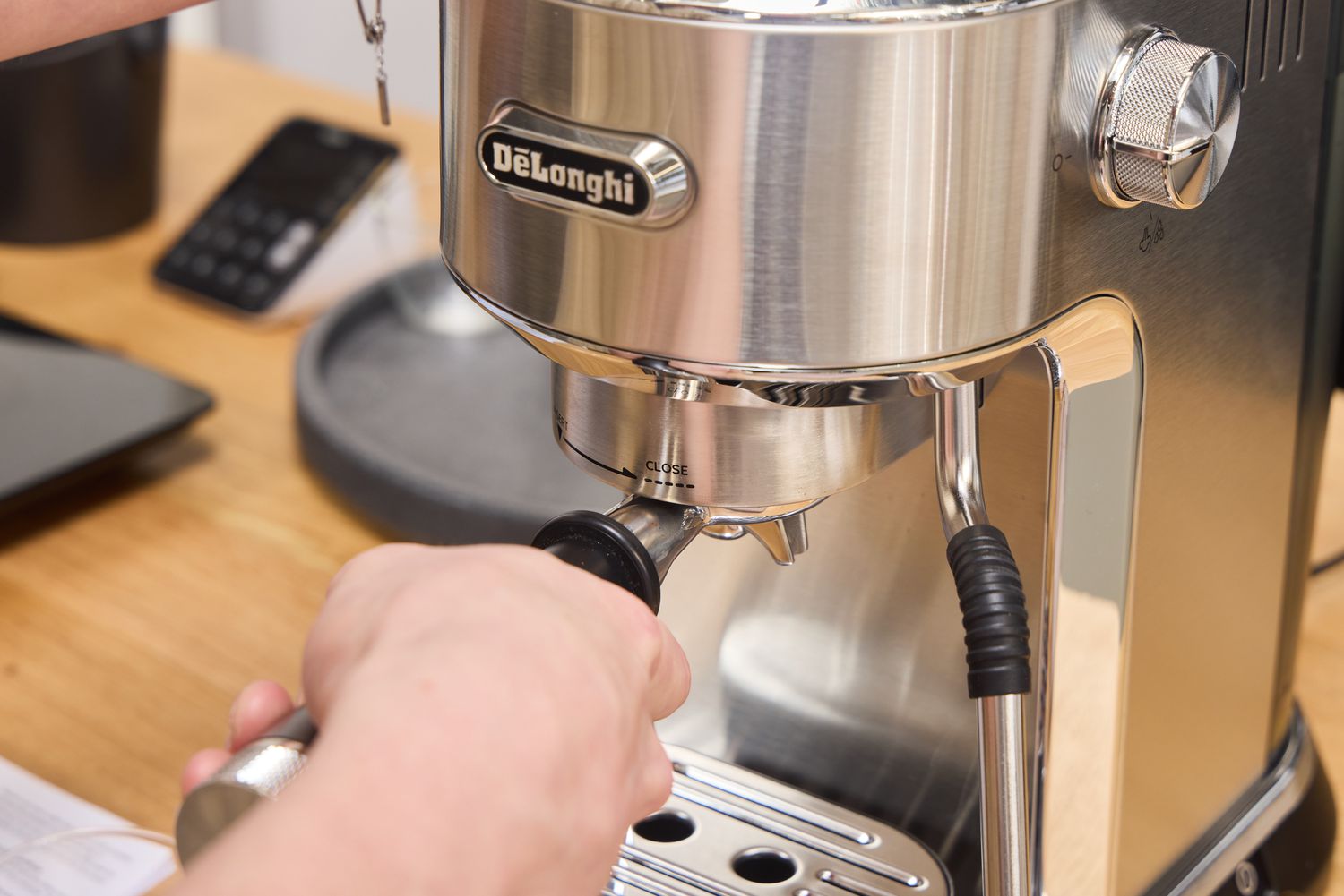A person attaches the espresso ground filter to the De'Longhi EC900M Dedica Maestro Espresso Machine