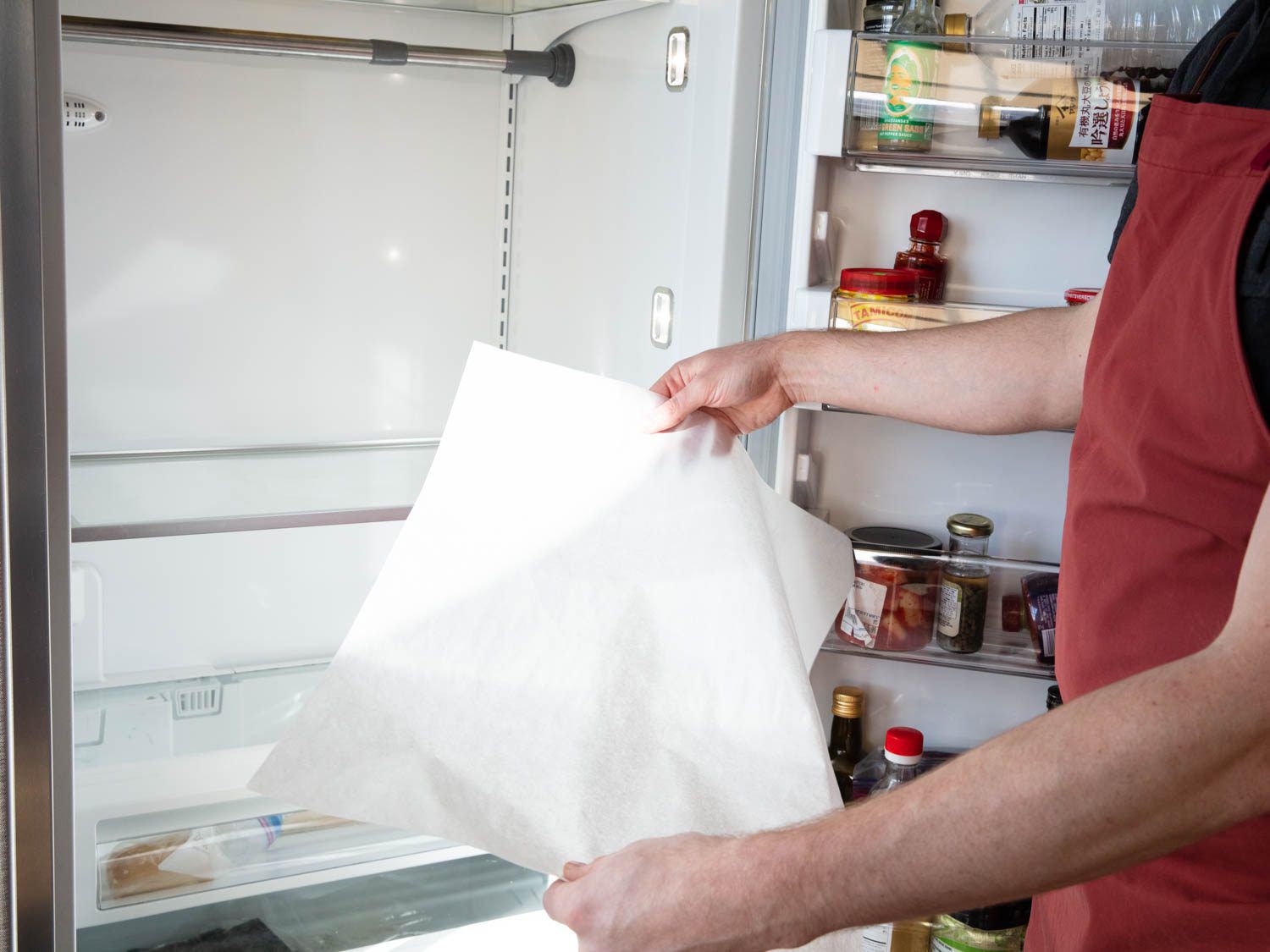 Lining a fridge shelf with parchment paper below the area where ducks will be hanging.