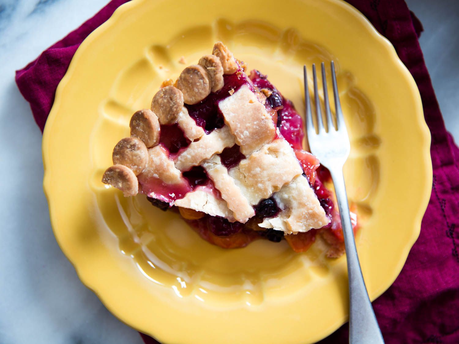Close-up overhead view of a slice of plated gluten-free berry pie.