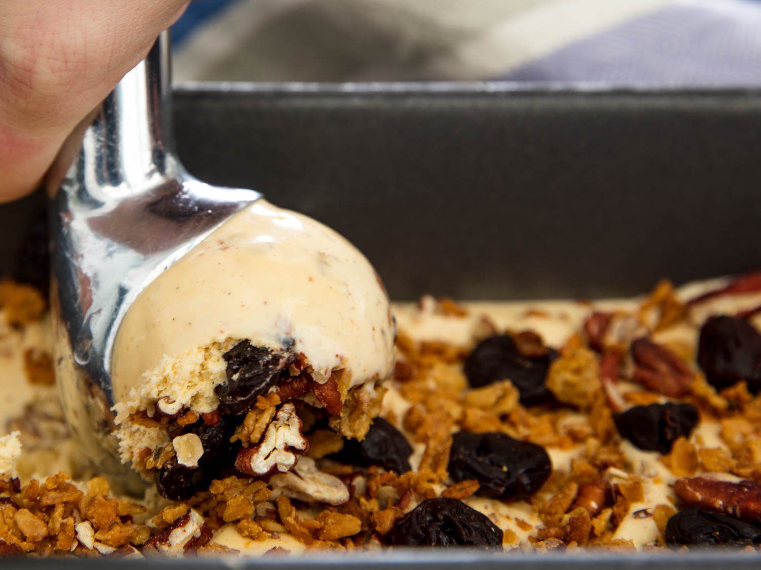 Scooping oatmeal cookie ice cream out of a loaf pan.