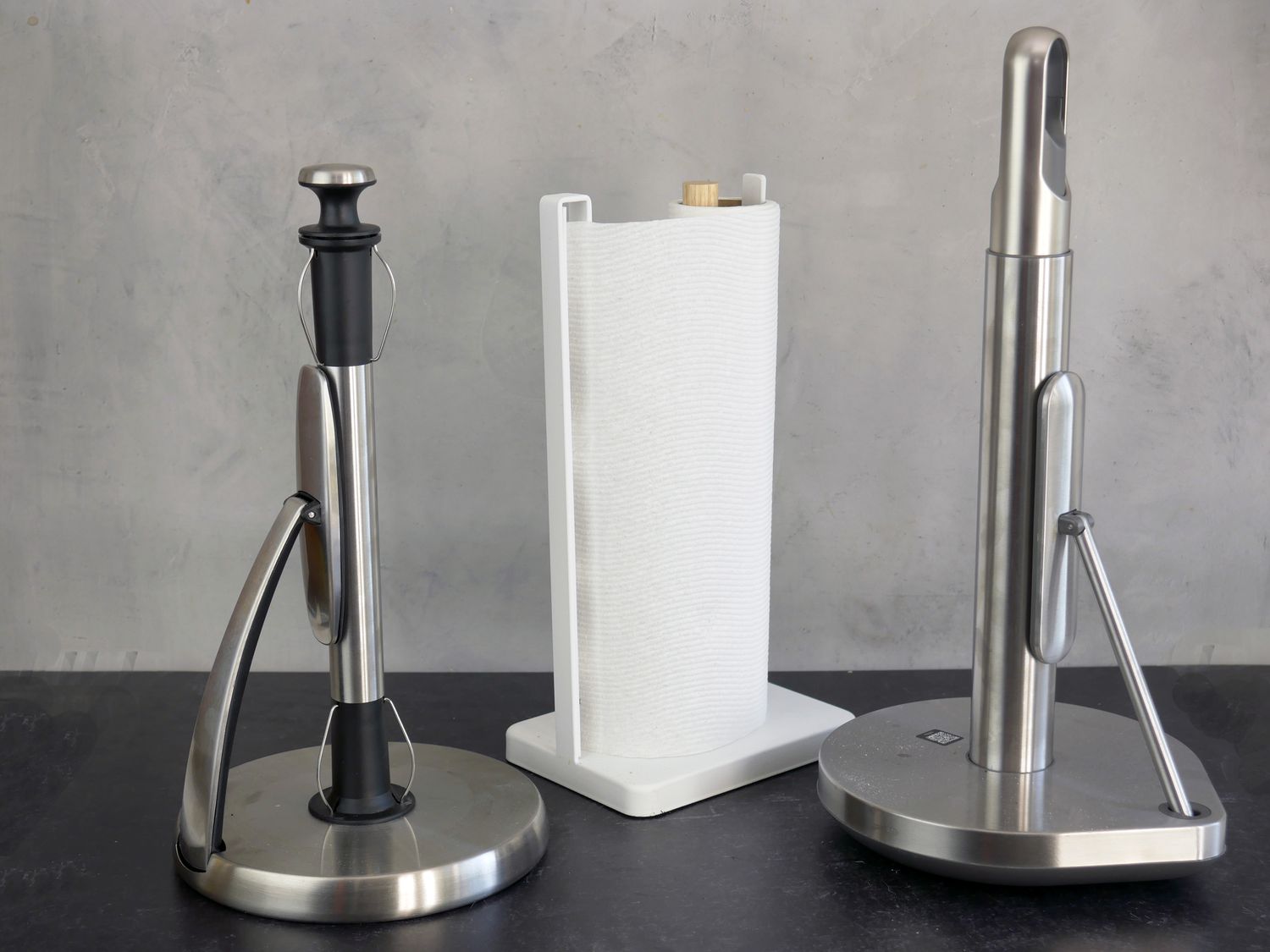 three different kinds of paper towel holders on a gray and black backdrop