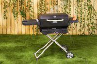 The Masterbuilt portable charcoal grill on a lawn.
