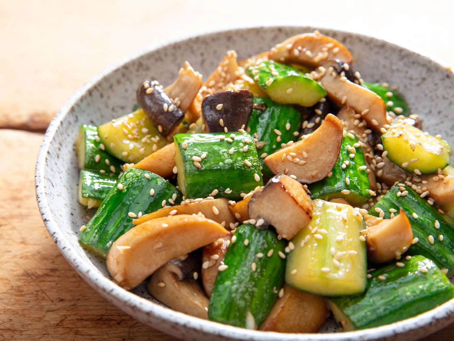 Closeup side view of stir-fried cucumbers with trumpet mushrooms.