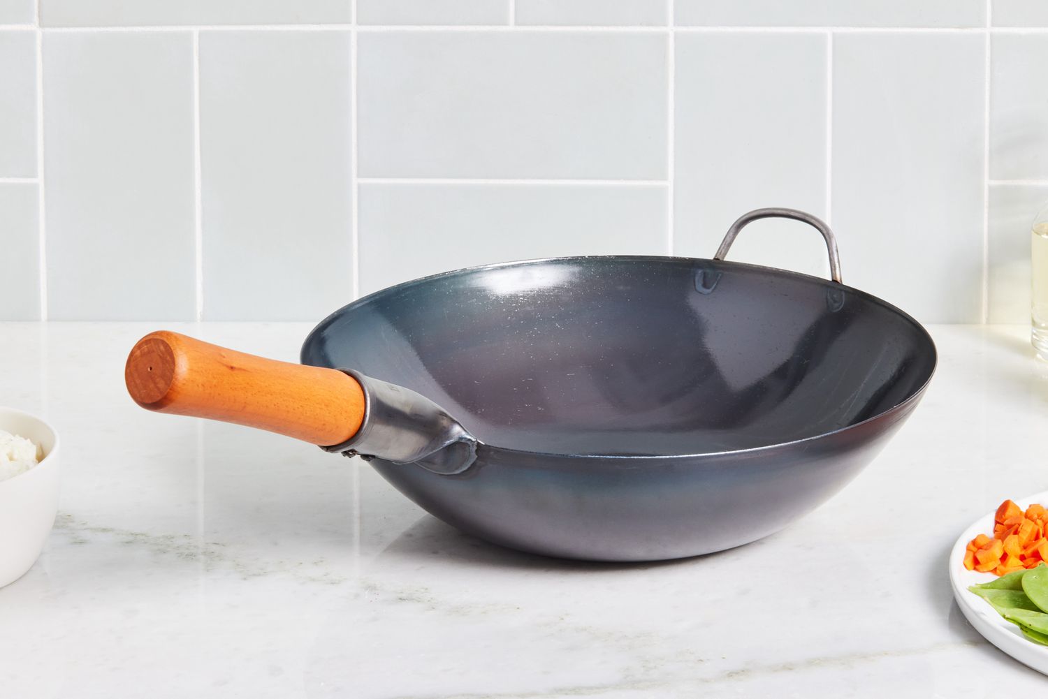 a carbon steel wok on a marble kitchen surface