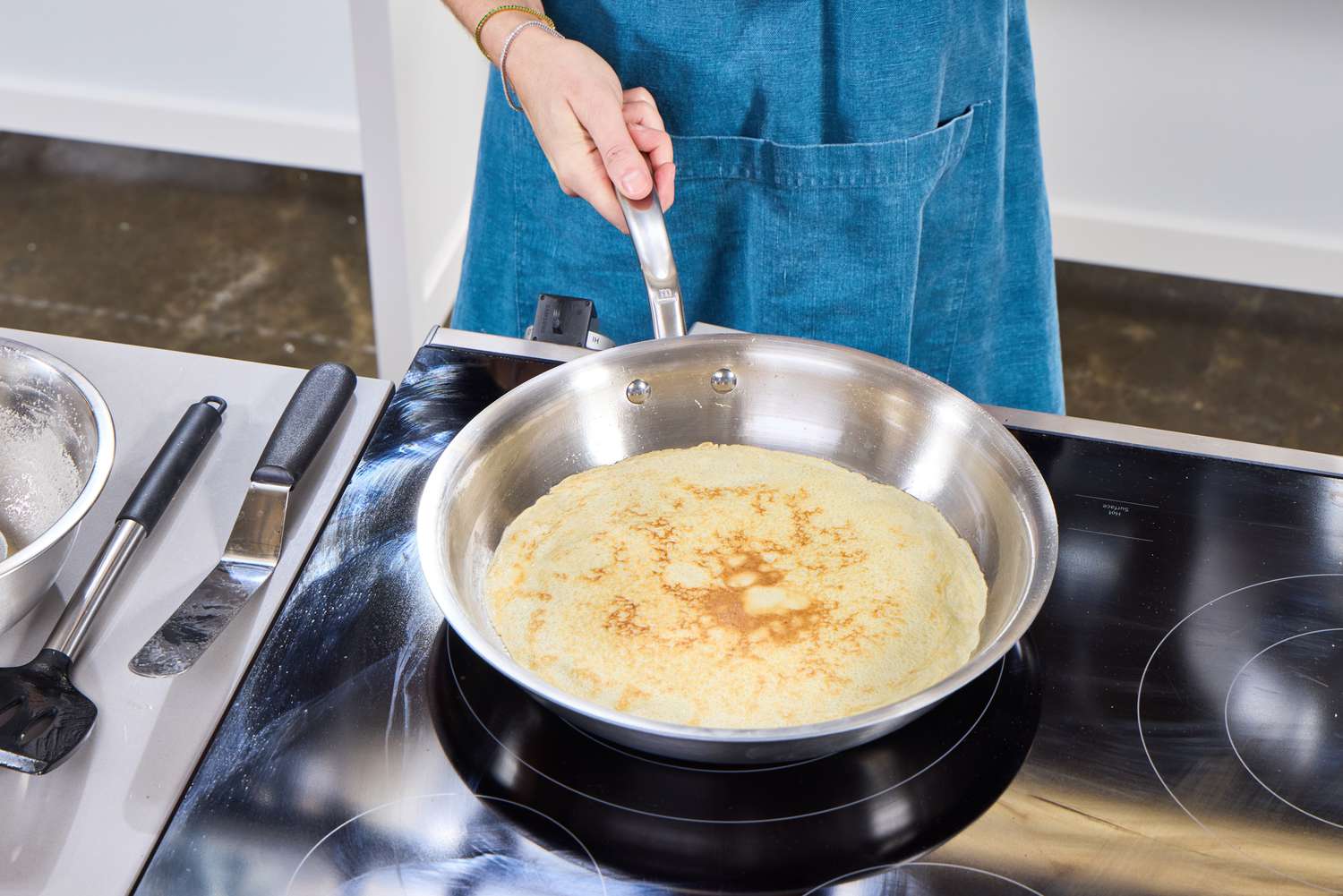 A person makes a crepe in the Made In 12-Inch Stainless Steel Skillet