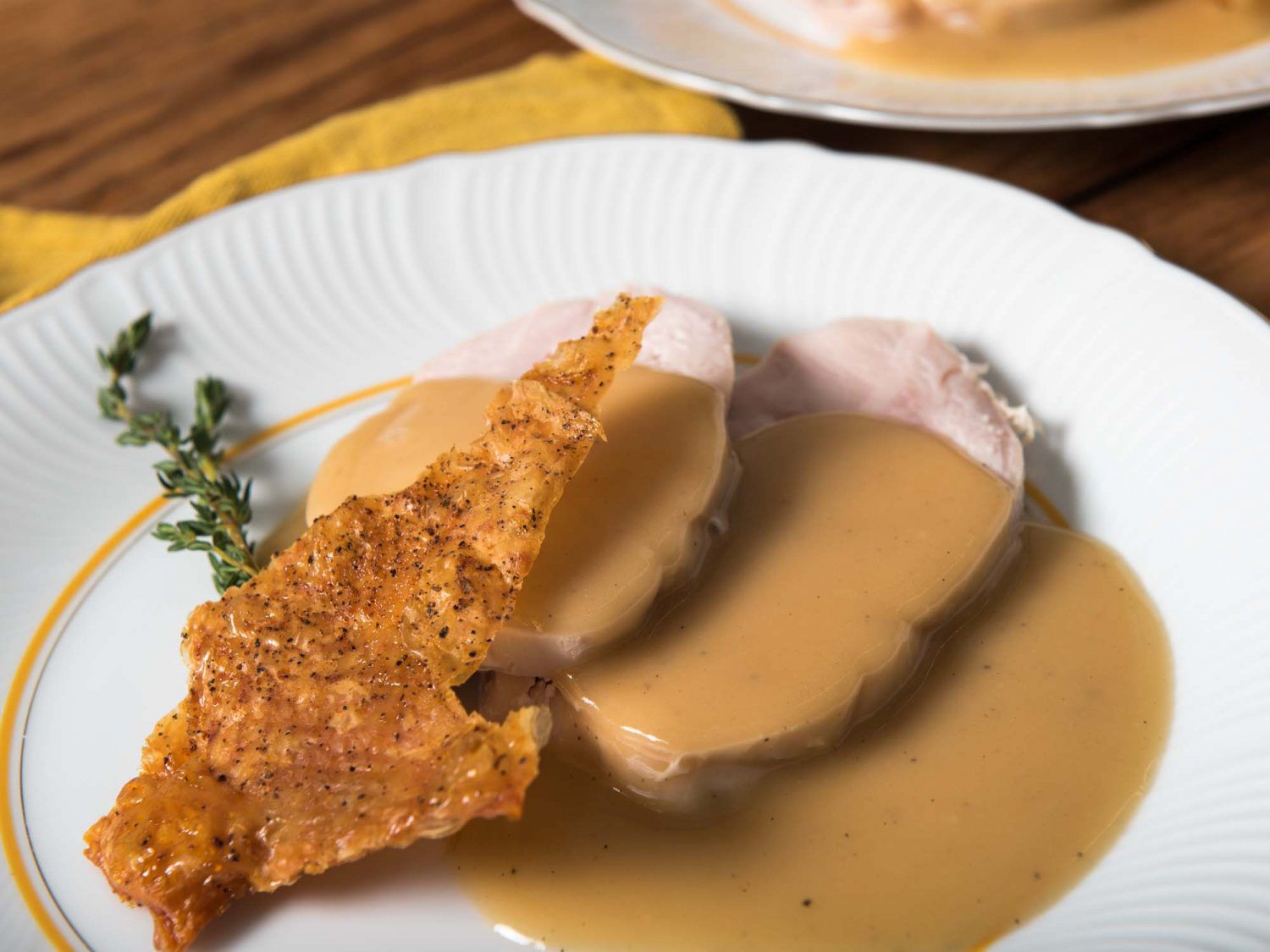 Close up of a serving of sous vide turkey breast with crispy skin and gravy