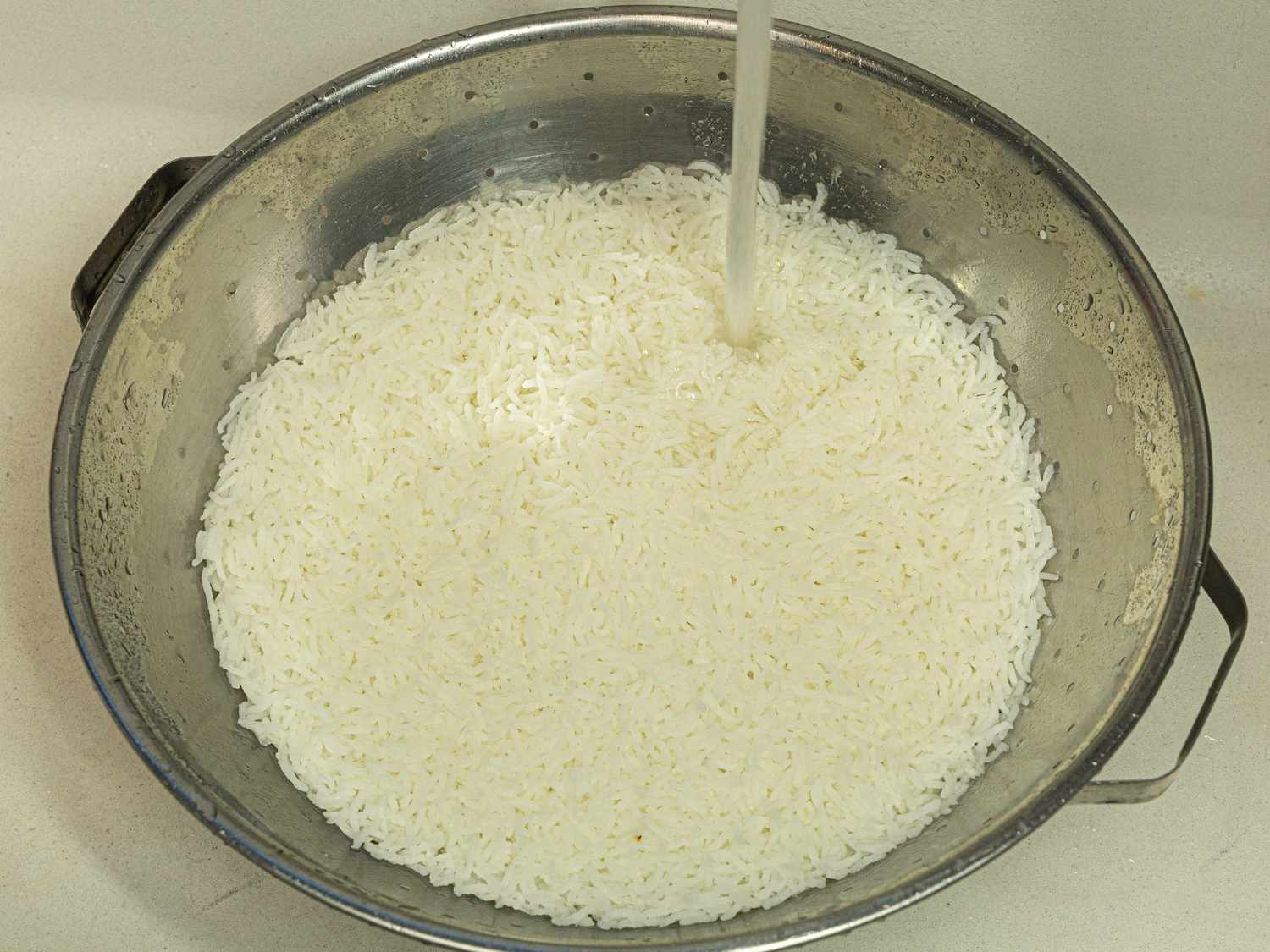 Overhead view of rinsing rice after paraboiling it