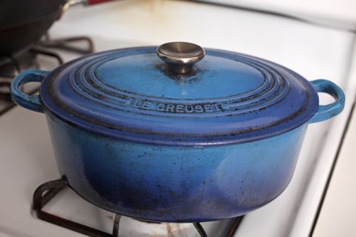 Well-used blue Le Creuset Dutch oven on stovetop