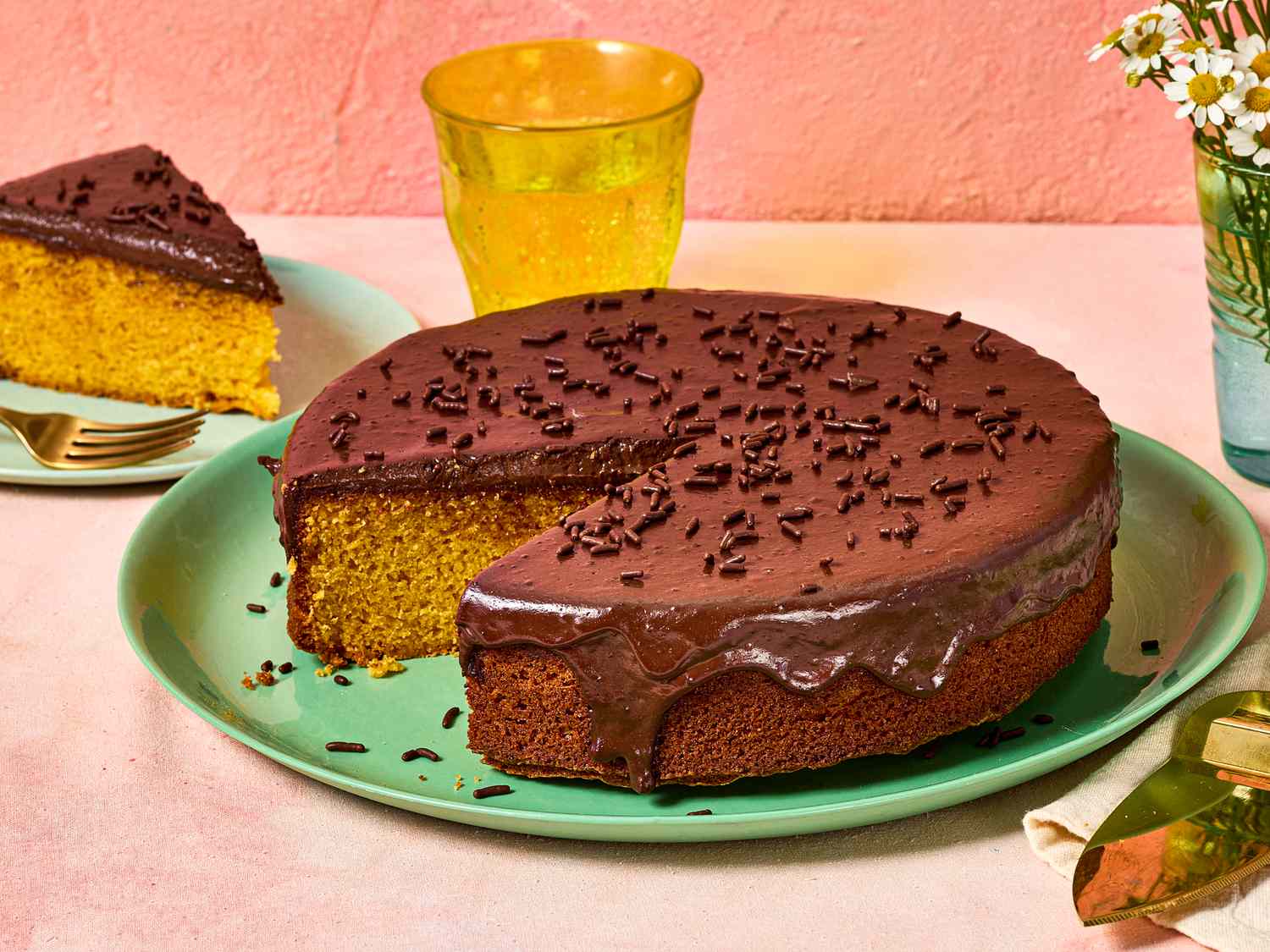Brazilian carrot cake topped with chocolate glaze, a slice is served nearby