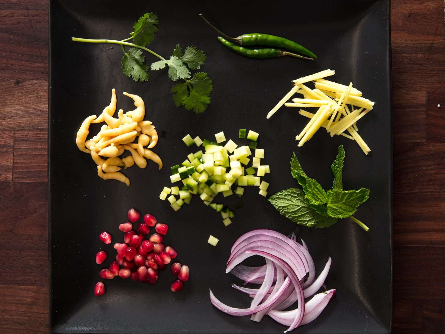 red onion, boondi, herbs, Thai green chilies, pomegranate seeds, diced cucumber