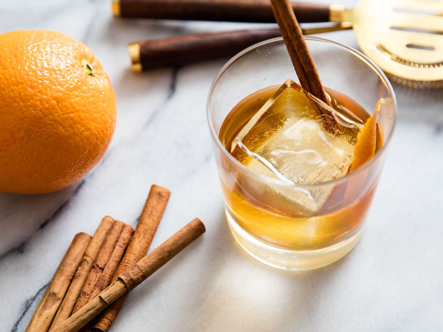 An old timber cocktail with whiskey, orange peel, and cinnamon sticks.