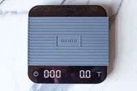 Acaia Pearl coffee scale with a protective cover and display showing zero readings