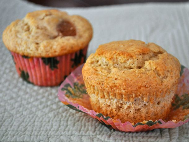 An unwrapped pear-cardamom muffin, with a wrapped muffin in the background.