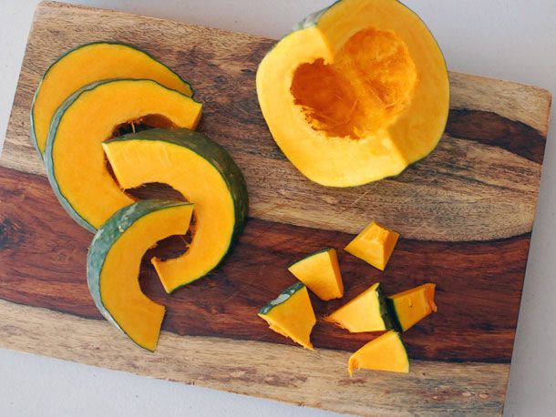 Kabocha squash quartered, in slices and chunks on cutting board