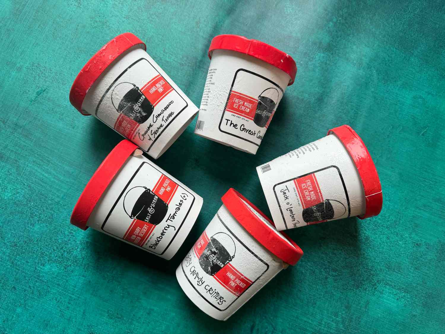 five pints of ice cream on a blue surface