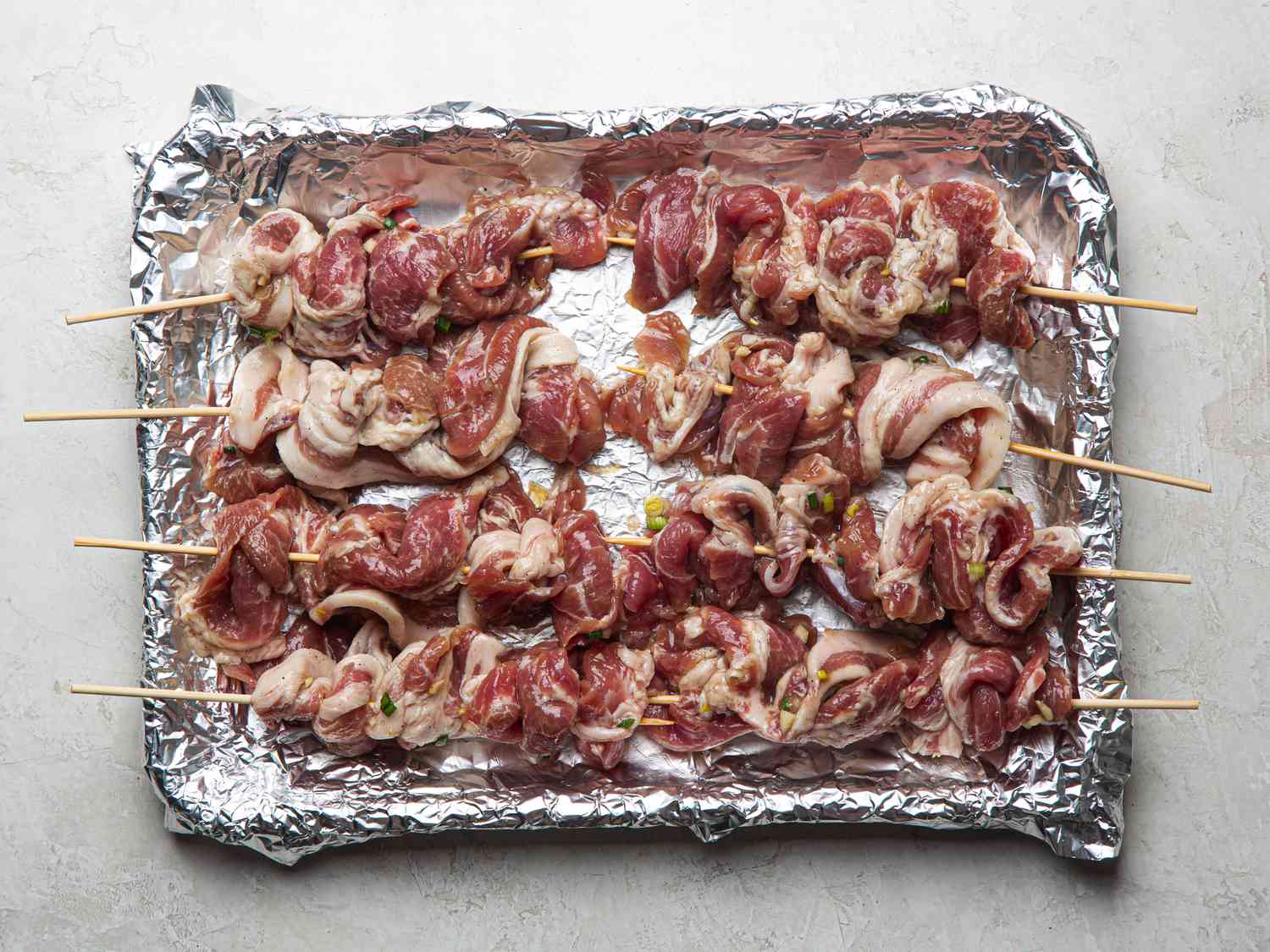 Overhead view of marinated pork on skewers