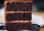 Slice of three-layer devil's food cake on a grey plate.