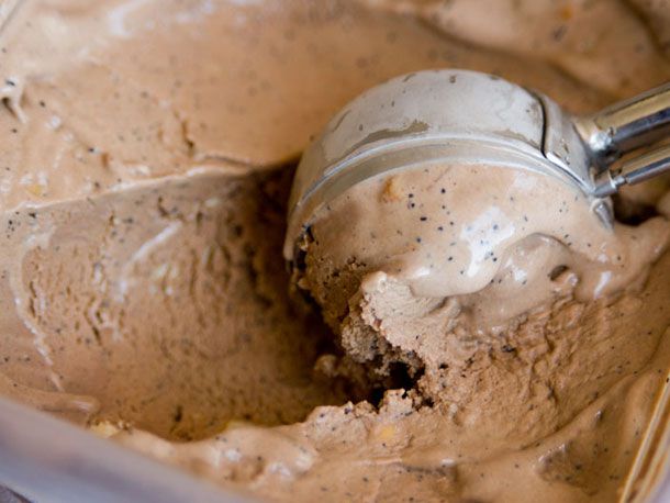 Closeup of mocha cashew ice creambeing scooped from a storage container.